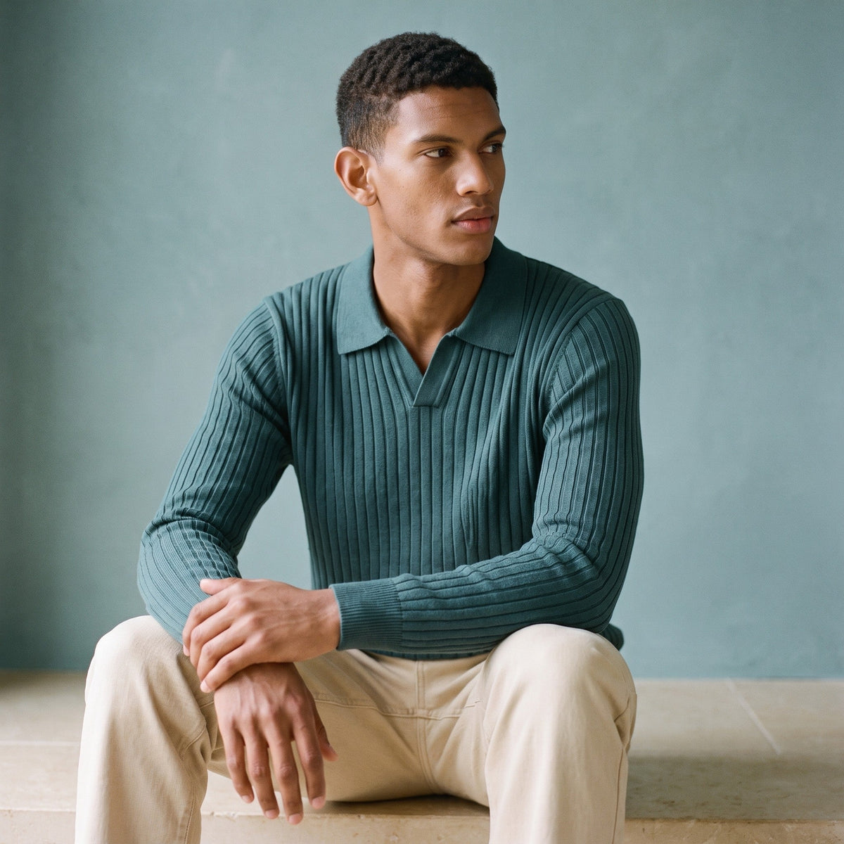 Man wearing a teal ribbed knitted polo jumper